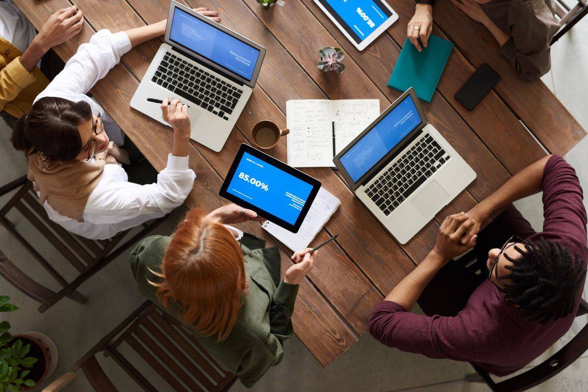 Team discussing business strategy with laptops and tablets